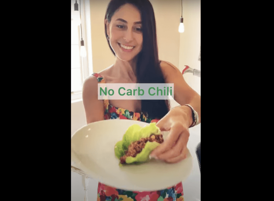 A woman holding chili lettuce wrappers
